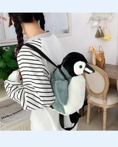 Süßer Plüsch-Pinguin-Rucksack, der von einem Model in einem gemütlichen Café getragen wird