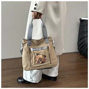 Detail view of khaki capybara tote bag with grey handles and front pocket zipper