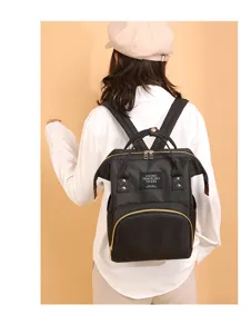 Vista posterior detallada de una mochila maternal negra de gran capacidad usada por modelo