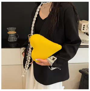 Vista detallada de un bolso de cuero amarillo en forma de corazón con correa LOVE de colores