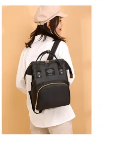 Elegante mochila pañalera negra multifuncional para mujer mostrada en una modelo