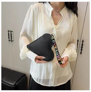 Primer plano de un bolso de mano negro con forma de corazón y correa LOVE de colores
