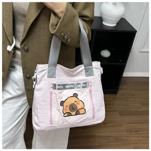 Detailed view of the cute pink capybara cartoon tote bag with silver lettering trim