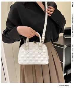 Primer plano de bolso tipo concha acolchado blanco con elegante asa y correa
