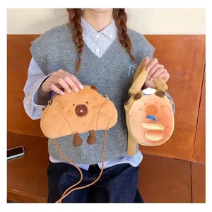Two cute capybara plush crossbody bags in croissant and round bread shapes on model
