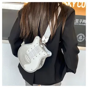 Detailed view of the silver guitar-shaped crossbody bag worn over a black blazer.