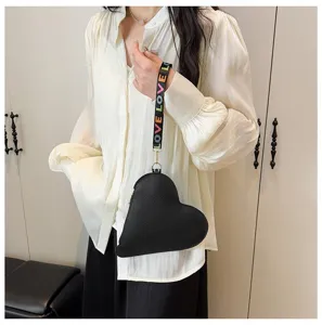 Bolso de mano negro con forma de corazón y una colorida correa con la palabra LOVE