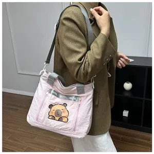 Detail of a cute pink cartoon capybara printed canvas tote bag worn by a student model