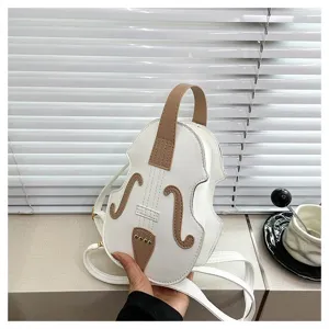 Detailed view of a creative violin shaped small backpack held in hand by a window blind.