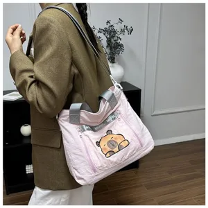 Cute pink cartoon bear tote bag shown worn by a model in a stylish lifestyle setting