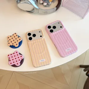 Λεπτομερής προβολή κομψών ριγέ θηκών iPhone σε ροζ και κρεμ με στηρίγματα σε σχήμα αστέρι.