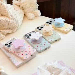 Gros plan de coques de téléphone à pois couleur bonbon avec supports étoile assortis.