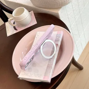 Vue détaillée d'une coque rose à pois avec un support d'anneau magnétique argenté intégré.