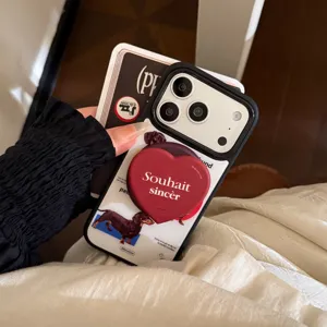 Gros plan d'une coque iPhone avec imprimé teckel et support magnétique cœur rouge.