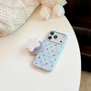 Gros plan d'une coque de téléphone à pois et d'un support magnétique en étoile sur table