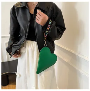 Detalle del monedero verde con forma de corazón y correa de muñeca LOVE de colores