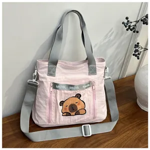 Detailed view of pink nylon tote bag with cute cartoon capybara print and grey straps
