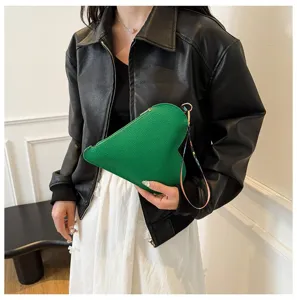 Vista detallada de un bolso de mano con forma de corazón en cuero verde para mujer.