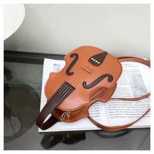 Detailed view of a stylish brown violin shaped crossbody bag on a magazine background