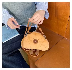 Adorable capybara plush crossbody bag featuring a soft croissant design in lifestyle setting
