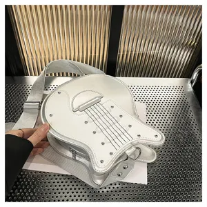 Detail shot of a stylish white guitar-shaped crossbody bag with silver hardware accents