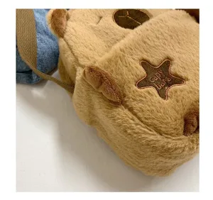 Gros plan sur la texture en peluche douce et la broderie étoile d'un sac capybara mignon