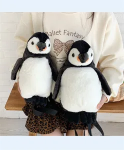 Detailansicht von zwei niedlichen Pinguin-Plüschrucksäcken mit weichem Fell, von Modell gehalten