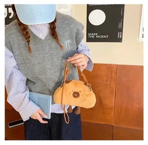 Close-up of a cute plush capybara crossbody bag held by a model in a stylish outfit.