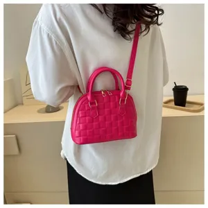 Modelo con un mini bolso de concha fucsia con una correa ajustable muy elegante