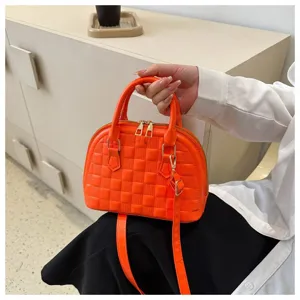 Bolso de mano naranja vibrante con patrón de rejilla en relieve y asas elegantes.