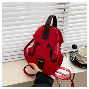 Detailed view of a unique red violin-shaped handbag held against a minimalist background