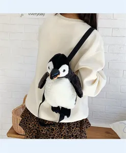 Rückansicht eines niedlichen Plüsch-Pinguin-Rucksacks, getragen als Umhängetasche