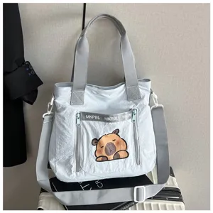 Detailed view of the cute capybara print and zipper pocket on a canvas tote bag.