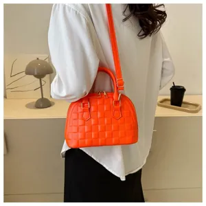 Vista trasera de una mujer con un bolso de mano con textura naranja brillante y forma