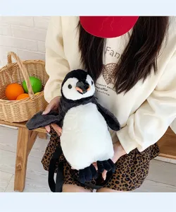 Niedlicher Pinguin-Plüschrucksack, präsentiert von einem Model in gemütlicher Umgebung