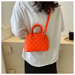 Moderno bolso tipo concha naranja con cuadros llevado como una bandolera elegante