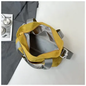 Internal details of a large yellow shoulder bag featuring a gray lining and inner pocket.