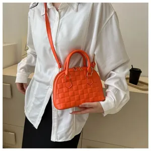 Bolso de concha acolchado naranja vibrante presentado en un elegante primer plano