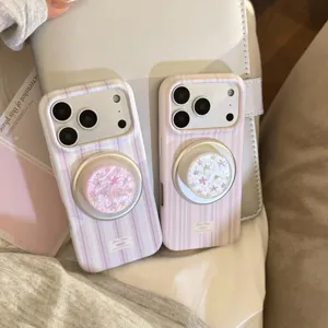 Détail des coques de téléphone rayées lavande et rose avec supports en nacre étoilée.