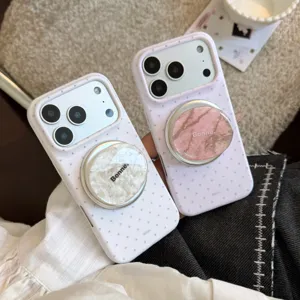 Λεπτομέρεια από λευκές πουά θήκες iPhone με ροζ και λευκές μαρμάρινες μαγνητικές λαβές.
