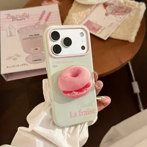 Vue détaillée d'une coque iPhone vert menthe avec un support en forme de donut rose