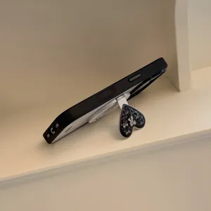 Gros plan du support de téléphone magnétique cœur noir avec motif nœud en dentelle française