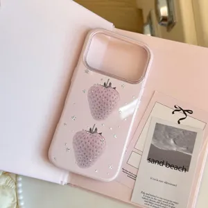 Gros plan d'une coque iPhone rose avec motifs de fraises et accents d'étoiles argentées.