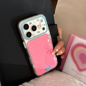 Gros plan d'une coque iPhone rose à pois avec d'adorables autocollants chaton et chiot