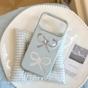 Détail de la coque de téléphone bleu clair avec nœuds élégants et accents étoilés.