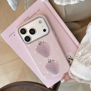 Vue détaillée de la coque iPhone rose avec motifs fraises sur un livre.
