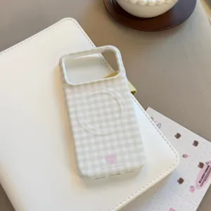 Vue détaillée de la coque MagSafe à carreaux verts avec cœur sur classeur blanc.