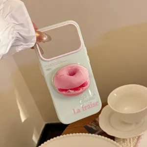 Gros plan d'une coque de téléphone vert pastel avec un motif de donut rose en 3D.
