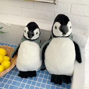 Zwei süße Pinguin-Plüschrucksäcke für Schüler in einer Küchenumgebung präsentiert