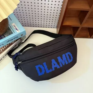 Close-up of a stylish black nylon chest bag featuring a bold blue DLAMD letter print